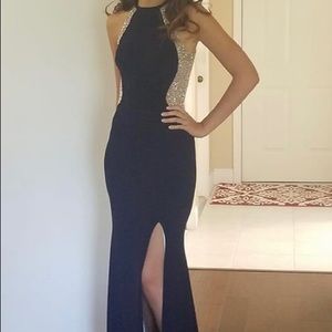 Long dark blue dress with silver details, has a cut by the right leg.